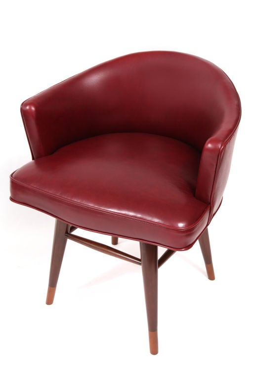 Pair of swivel armchairs model number 4876 by Edward Wormley for Dunbar, circa late 1950s. These examples are done in a soft and supple maroon leather with solid two-tone walnut legs. Excellent restored condition. Price is for the pair.