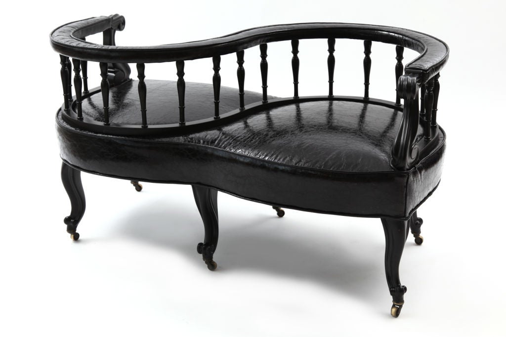 Glamorous loveseat courting chair, circa early 1940s. This example has wonderfully sculpted cabriolet legs and hand-turned wood back rests. The frame has recently been done in black lacquer and the upholstery is a high sheen richly textured black