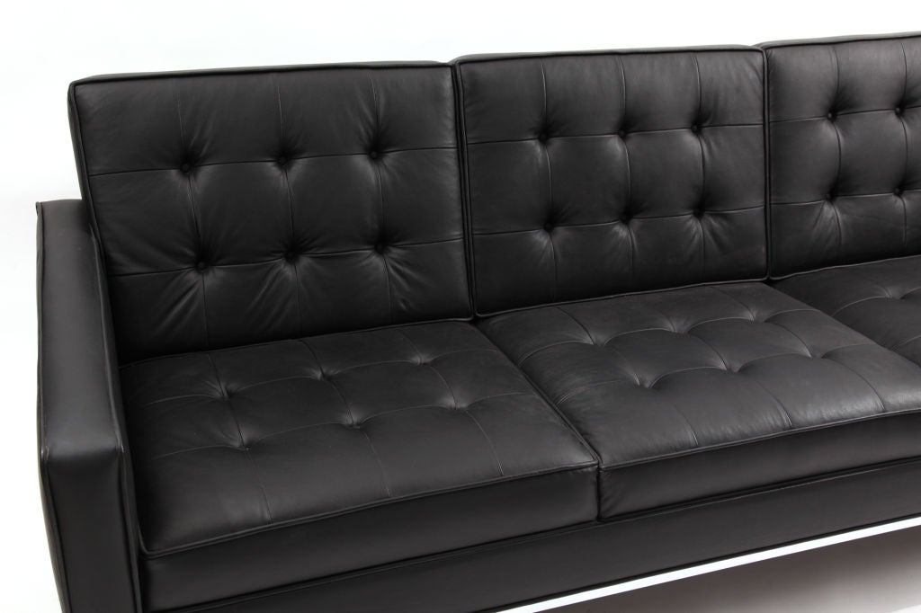 Button tufted leather and chrome sofa circa early 1970's. This example has a tight seat and back and is done in a supple black leather. The chrome base circumvents the entire sofa and the back legs are splayed.