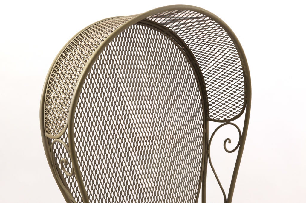Sculptural wrought iron hooded chair circa early 1960's. Features steel mesh seat back and hood with formed wrought iron frame. This chair is all original and is done in a wonderful fern green color. Great as an accent piece outdoors