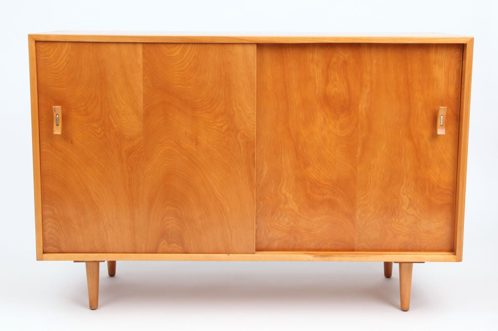 Stanley Young for Glenn of California chest of drawers circa late 1950's. This example is done in beautifully grained maple and has three interior drawers and adjustable interior shelving behind the pair of sliding doors. The pulls are done in a