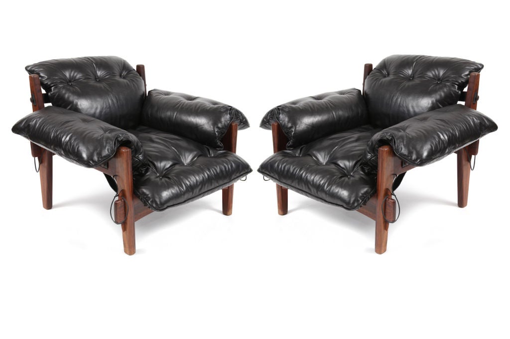 Pair of Sergio Rodrigues Poltrona Moleca or Mischievous Chairs circa early 1960's. <br />
These examples have solid stout rosewood frames in their original finish and are upholstered in their original beautifully patinated black leather. All the