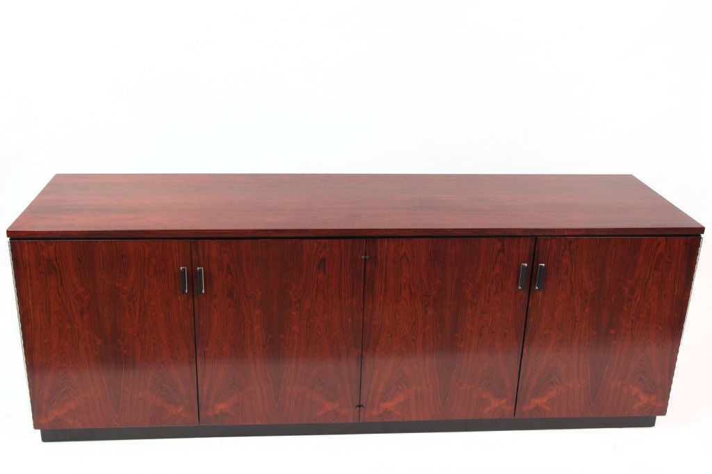 Brazilian rosewood and black lacquered credenza by Founders circa late 1960s. This chest has a beautifully grained rosewood exterior with black and chrome metal door pulls. The four doors open to reveal an interior that has two large drawers and two