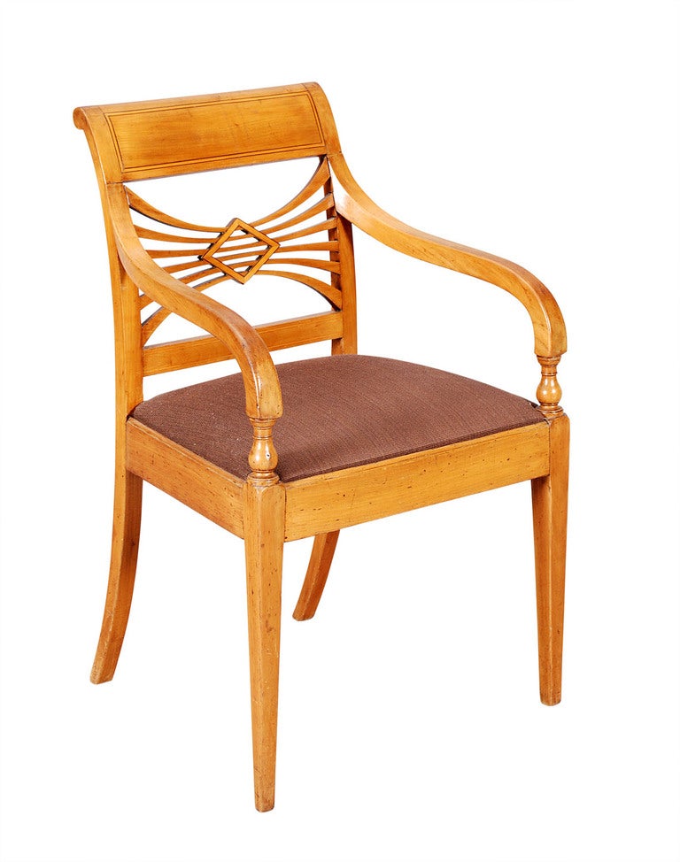 A Neo-Classical fruitwood armchair with beautifully designed back. The curved arms terminate with a turned support at the drop-in seat. With square tapering front legs and outswept back legs. In a warm, mellow patina. A set of four matching side