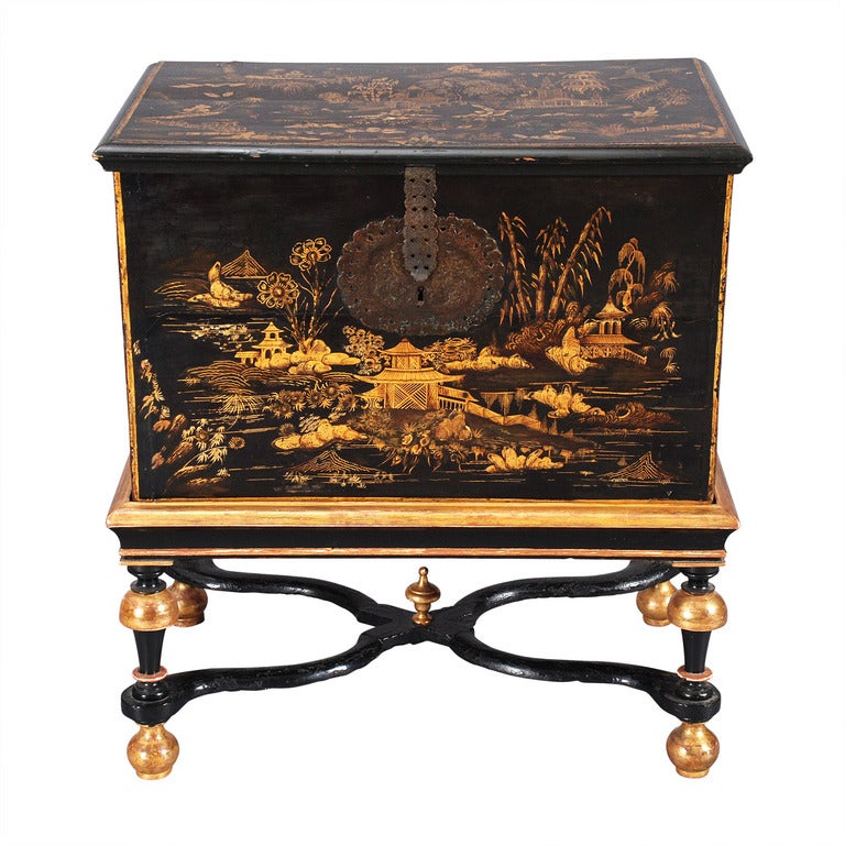 An English black japanned box on later stand. The quality of the decoration is extraordinary. Retaining all the original Asian-inspired hardware. Raised on a turned-leg stand connected by shaped X-stretchers surmounted by a finial.