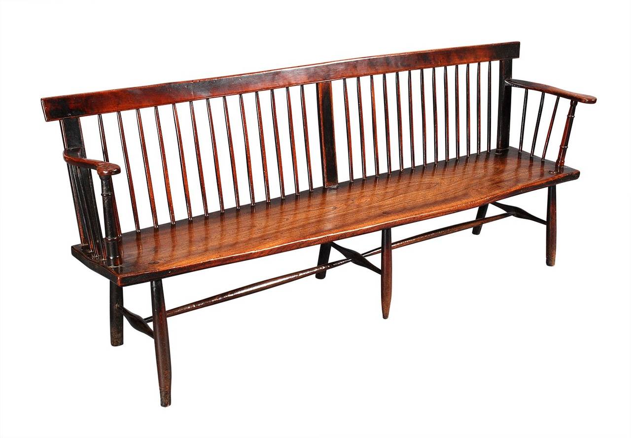 A spindle-back settee of great size. The seat is formed of one single slab of well-figured elm; the remainder is in beech. Completely original throughout and retaining an outstanding color and patina. The simple lines and rich surface make this a