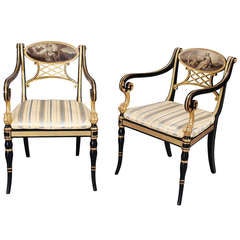 A pair of Regency black and gilt armchairs