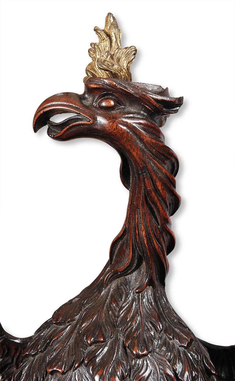 A masterfully carved mahogany phoenix with gilt bronze finial in the shape of a flame. A fragment from a larger piece. Retaining a rich and warm patina.