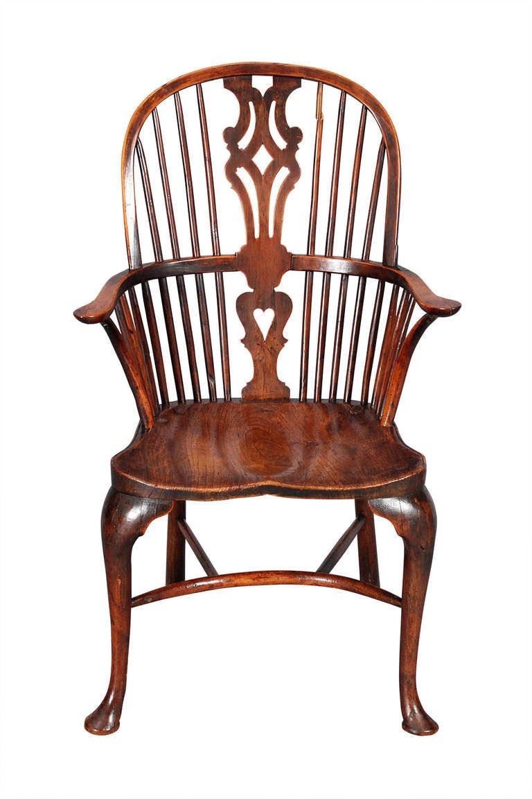 A yew-wood and elm Windsor armchair with cabriole front legs connected by a bent-wood, crinoline stretcher. With a shaped saddle seat. Retaining a great color and patina.