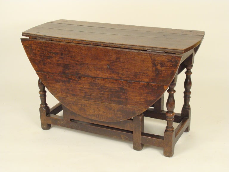 Early 19th century English oak gate leg table. This table has a great old finish, and the wood is robust. The dimensions are, height 27 1/2