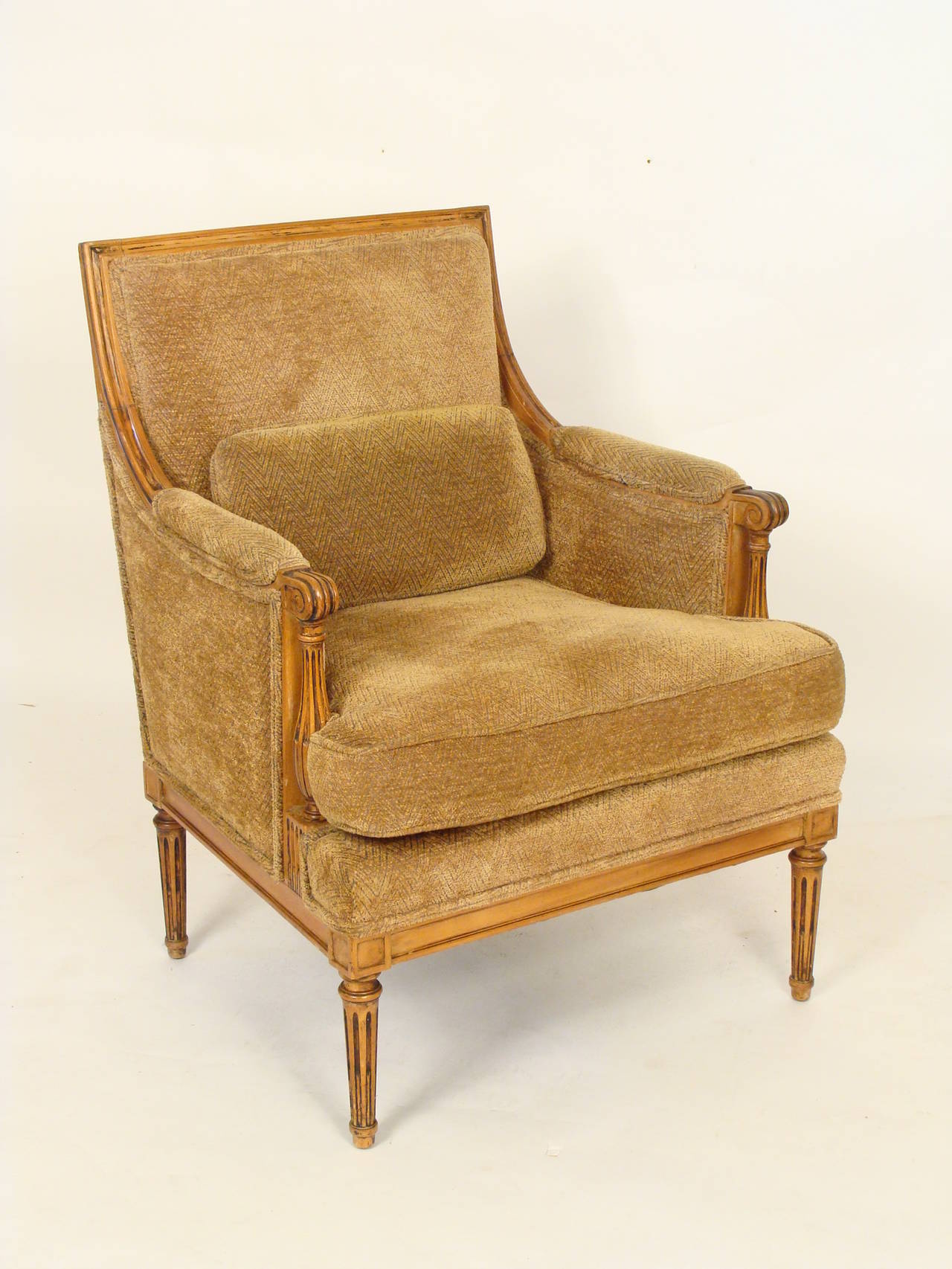 Pair of Louis XVI style fruitwood bergères, circa 1930-1950. The frames on these chairs have excellent color. These chairs are very comfortable.