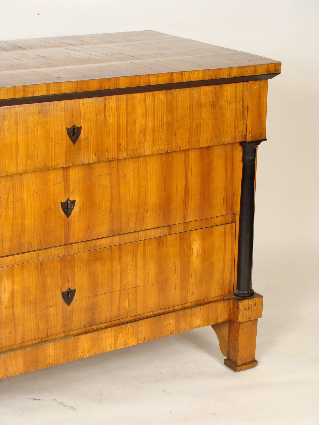 Biedermeier fruitwood or walnut chest of drawers with ebonized columns, circa 1825.