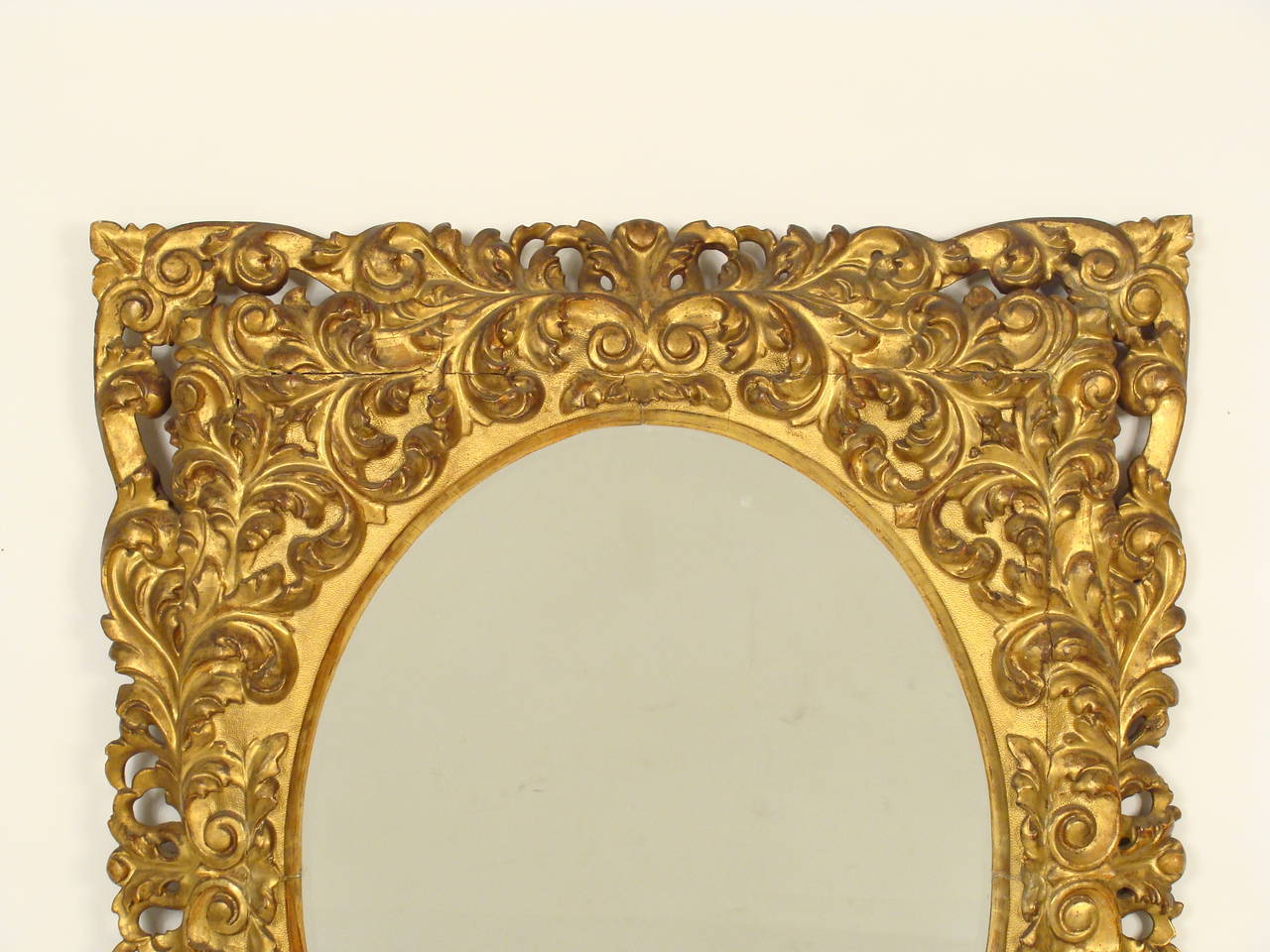 Italian Baroque style giltwood mirror, 19th century. This mirror retains its original old gold leaf finish.