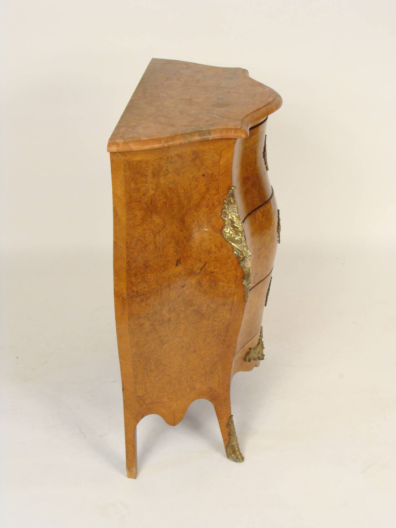 Louis XV style burled elm commode with brass mounts and a marble top, circa 1920. This commode has exquisite burled surfaces. Stamped under the marble made in France.