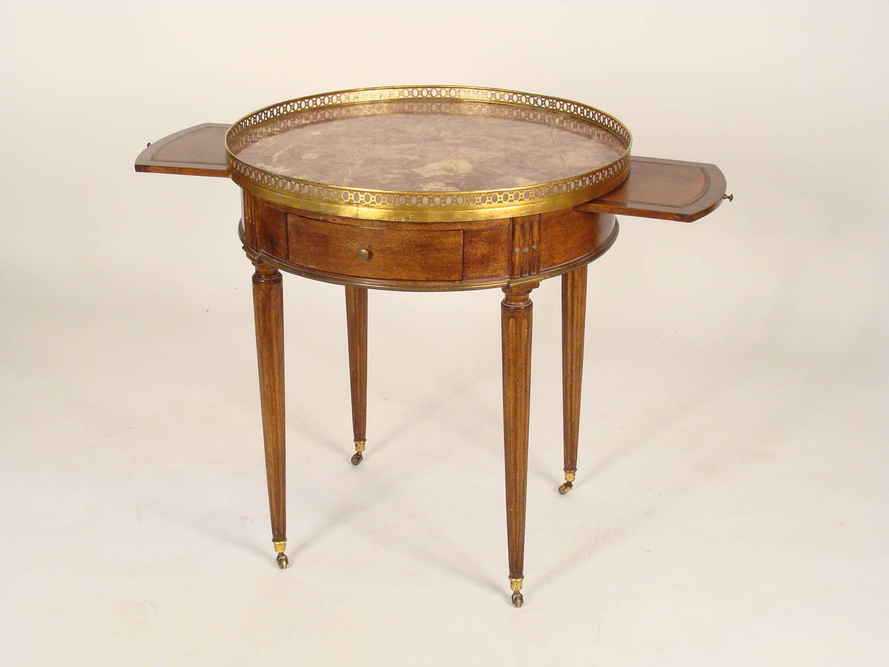 Louis XVI style brass mounted mahogany bouillotte table with a marble top, circa 1900. The height is 28.25