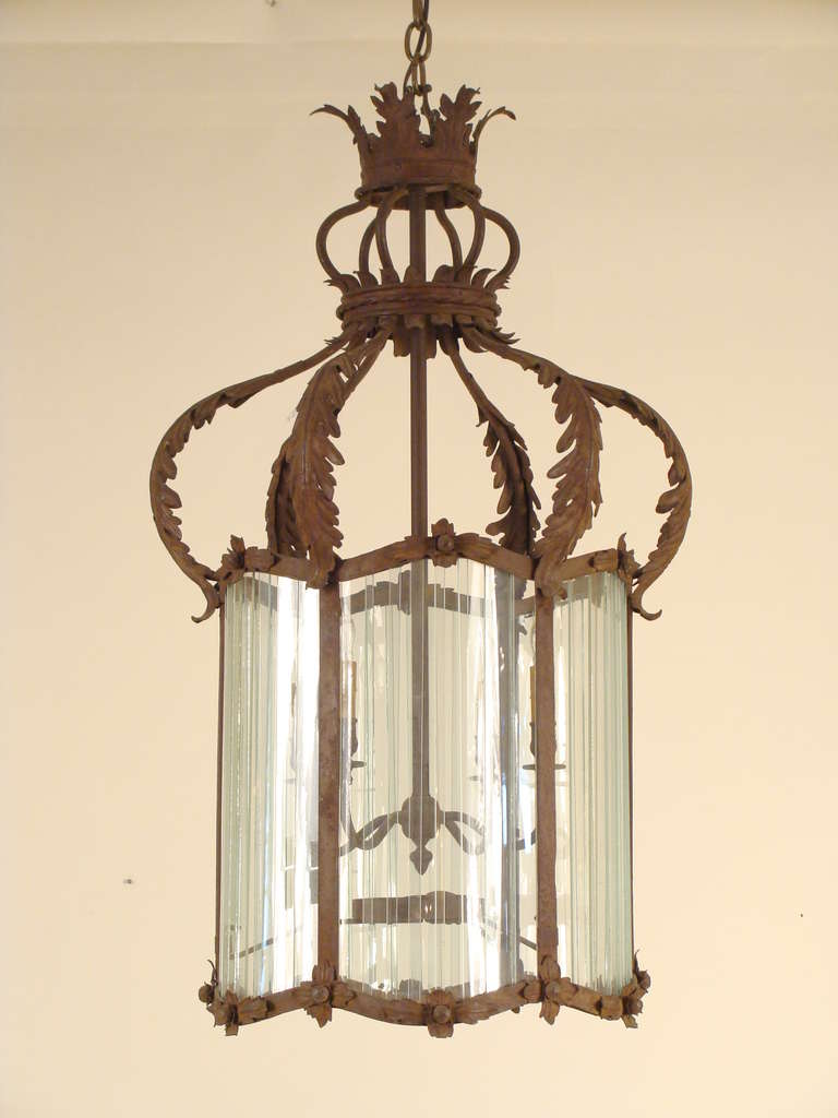 Iron and glass 4 light lantern, circa 1980. This lantern has a corona style top and vertical slats of glass. On the bottom of the lantern there is a label that indicates this lantern was once the property of Antonio's antiques in San Francisco. If