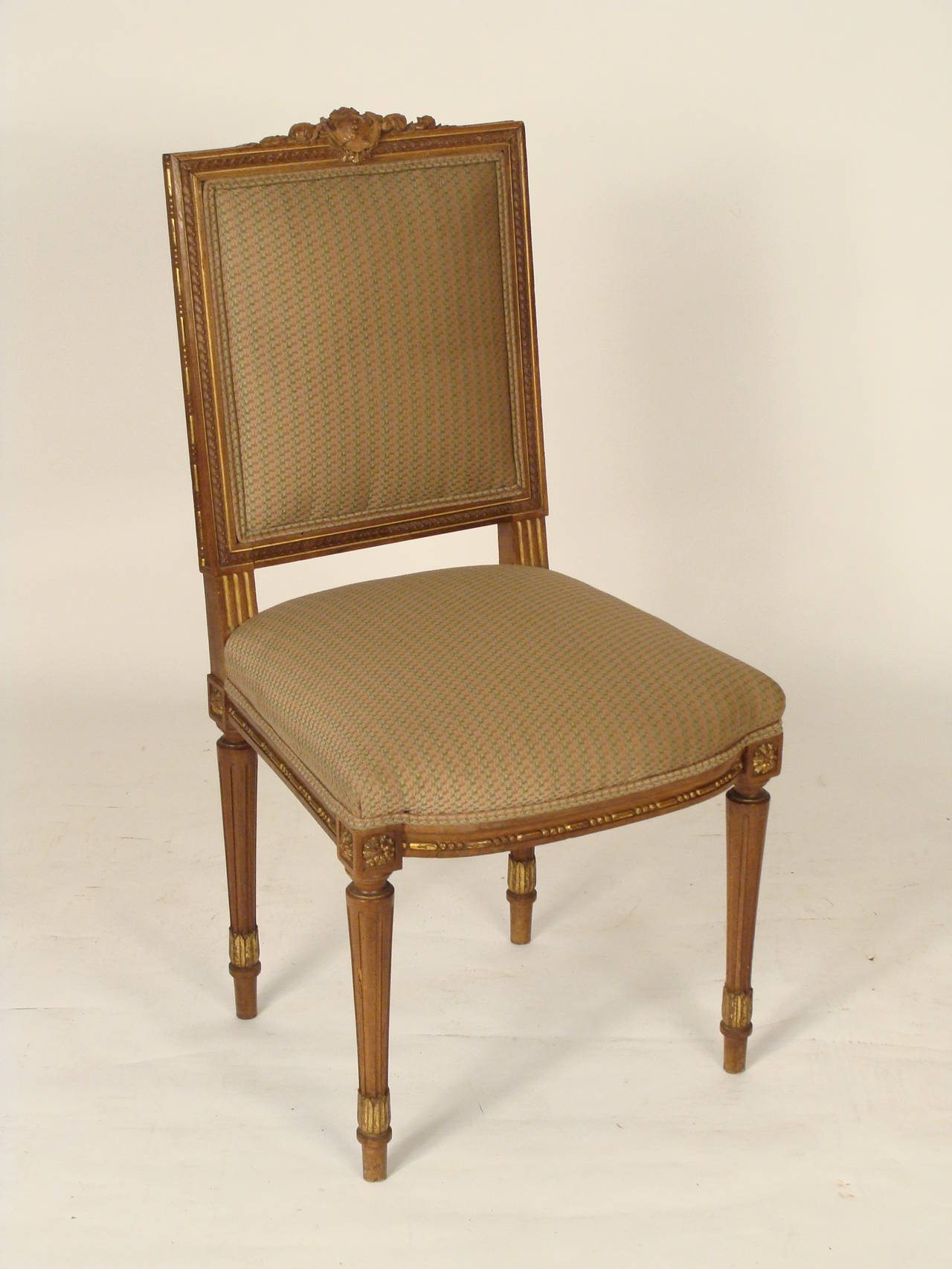 Set of four Louis XVI style carved and partial-gilt beechwood side chairs, circa 1920.