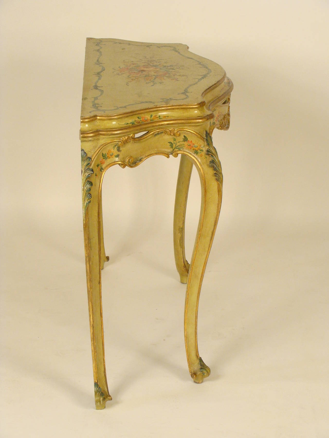 Italian Louis XV style painted and partial gilt console table, mid-20th century. This table has beautiful hand-painted floral decoration and gilt highlights on the top, apron and legs.