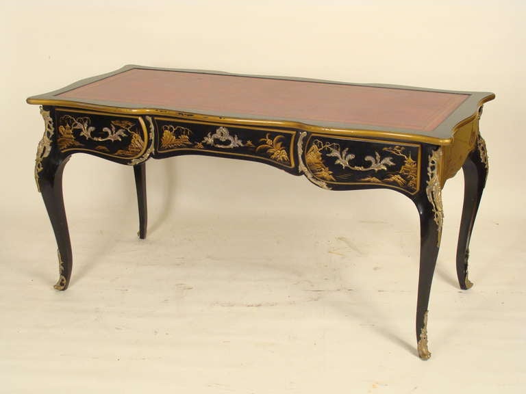 Louis XV style chinoiserie decorated bureau plat with a red leather top, raised chinoiserie decorations and brass mounts, circa 1980.