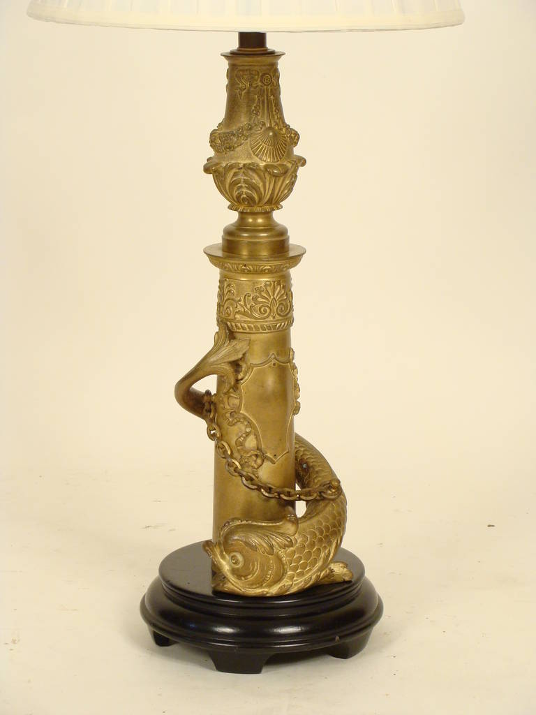 Pair of continental  gilt bronze dolphin form lamps with wood bases, circa 1900.  The height from the base to the top of the lamp finial is 31.5