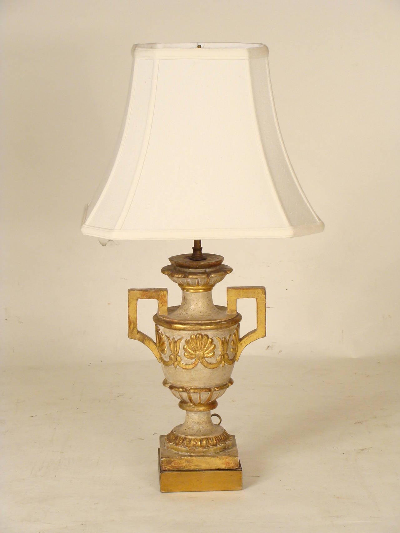 Continental neoclassical style painted and giltwood decorated table lamp, late 19th century. This lamp has very nice quality gilding and crusty paint. The height from the base to the electrical fittings is 16