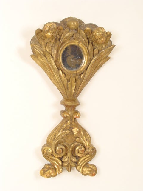 Ostensoir en bois sculpté et doré de style baroque, 19e siècle - Bel objet religieux en bois doré avec des anges, des feuillages et des pieds en forme de pattes. Le miroir inséré est un ajout ultérieur.