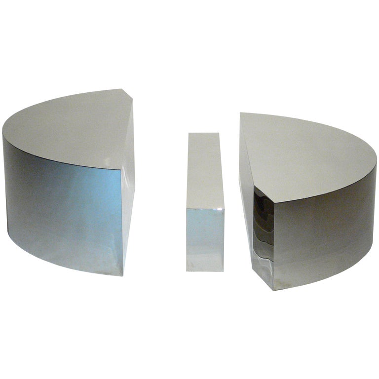 Three-piece chromed cocktail table of varying heights.