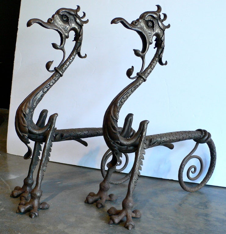 A pair of incredible hand-forged iron dragon andirons. These were not cast from a mold but entirely hand-formed and hand-chiseled by a master blacksmith. There are no weld marks. All elements were hand-pegged in place and not welded. These andirons