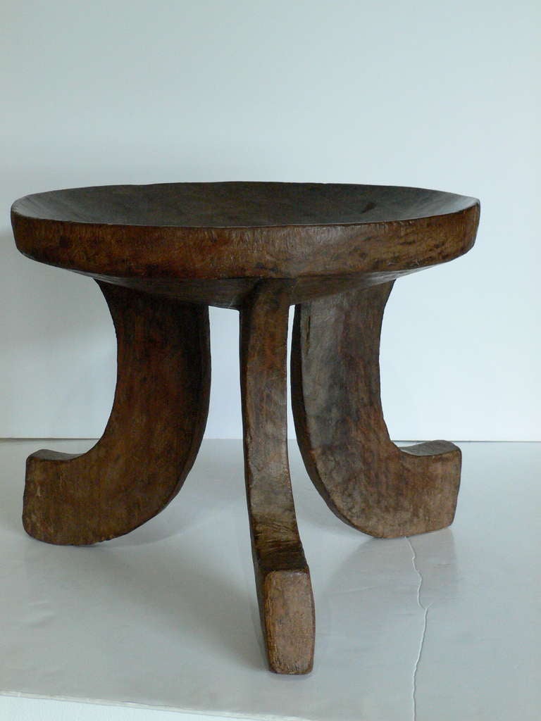 Early 20th century Ethiopian Jimma stool with a deep concave seating surface. Hand-carved from one piece of solid wood and used by the Oromo people of Ethiopia.