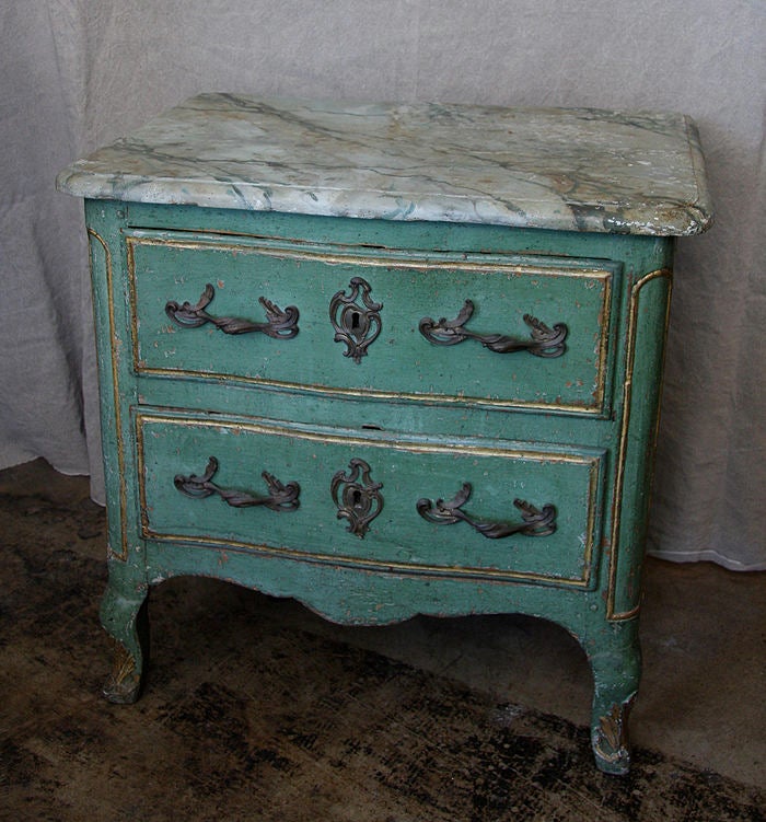Petite painted French commode, in pale French green, with a faux marble top, and two drawers, with bronze handles.
