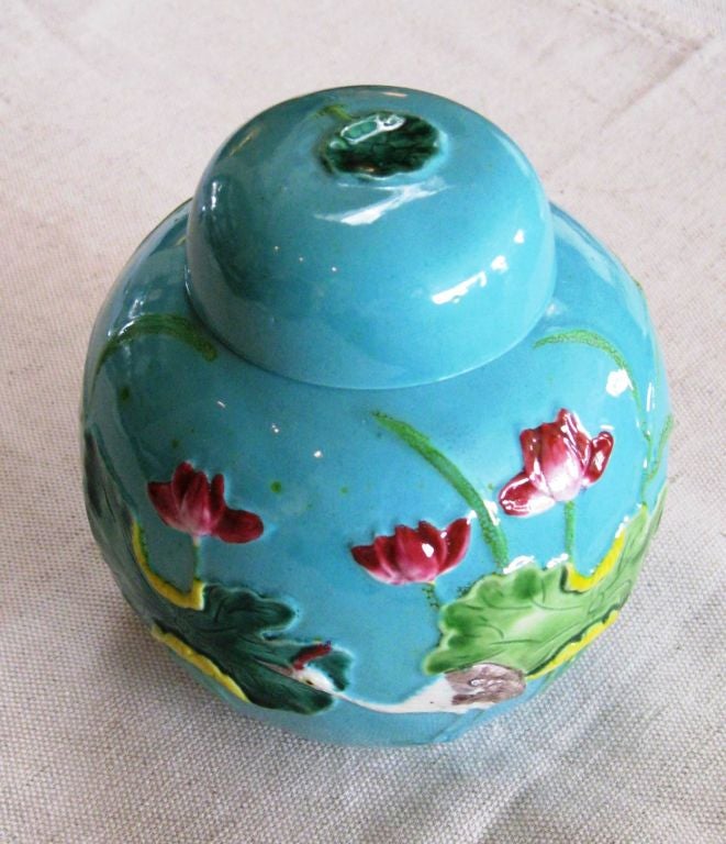 Enchanting Chinese applique ware porcelain ginger jar with a crane and lotus motif. The overall background glaze is a robin egg blue with deep rose lotuses.