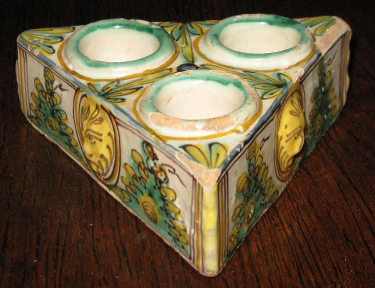 Ceramic polychrome salt cellar in turquoise, cream and yellow; with masquerone and foliage motif; with three bowls.