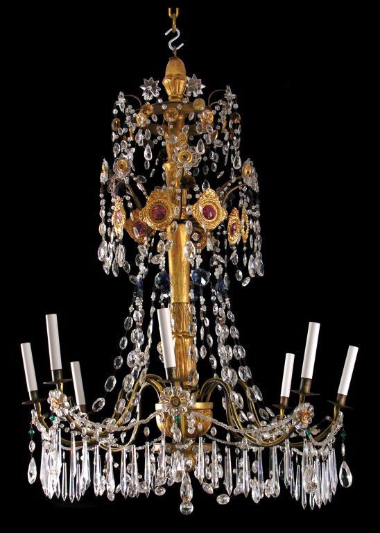 A fine eighteenth century Genoese chandelier with beaded swags emanating from crystal floral motifs from which hang oval and icicle prisms.  The chandelier has three orders or tiers with crystal jewels of emerald, topaz, sapphire and clear crystal