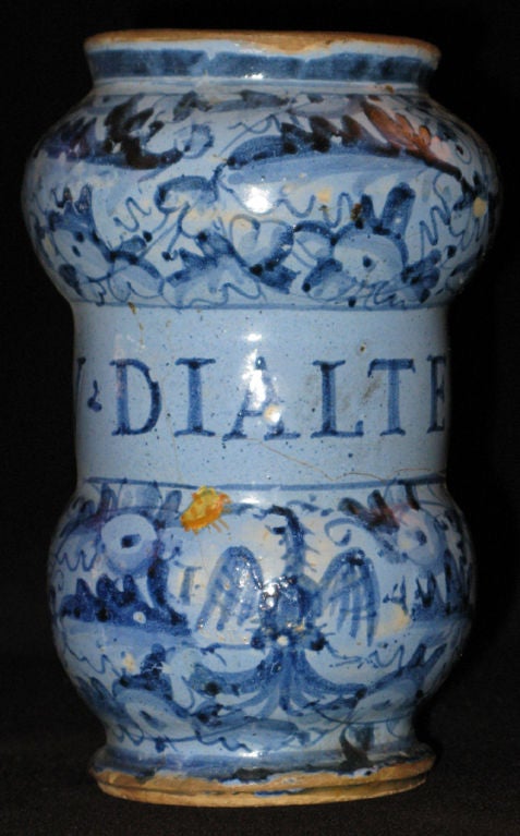 A blue tin-glazed earthenware albarello with an inscription in a central band that refers to “Vinum made from pepper.”