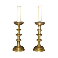 A pair of bell metal pricket candlesticks