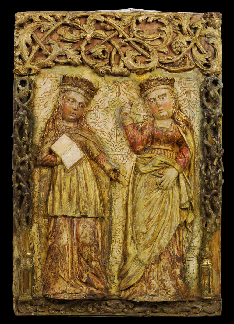 The sweet, typical doll-like figures of the Lower Rhine are standing below a gilded gothic tracery valence and framed by reticulated twig carvings stemming from a pair of urns on pedestals reaching to the bottom of the upper carving.  The carved