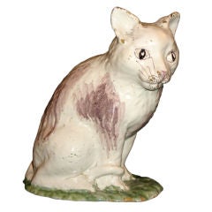 A faience model of a seated cat painted in green & manganese red