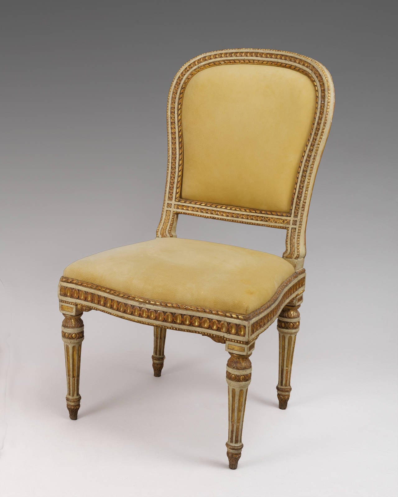 A pair of finely painted, carved and gilded chairs, of generous proportion with drop in seats and backs; with original paint and gilding. 
Emilia, Italy circa 1780