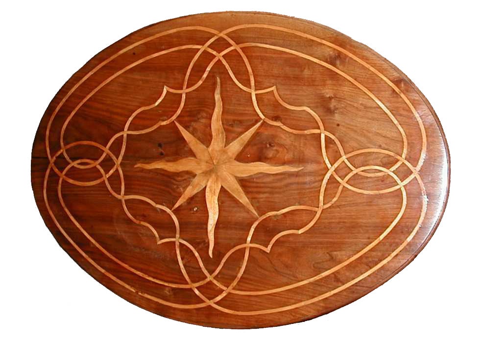 A walnut oval tilt-top table inlaid in fruitwood with a central star motif surrounded by scrolling inlay design, the top resting on a pedestal base supported by tripod legs, ending in pied de bouche feet.