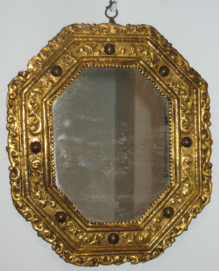 A rare gilt copper repousśe octagonal mirror with inset hard stones 
Italy, circa 1600