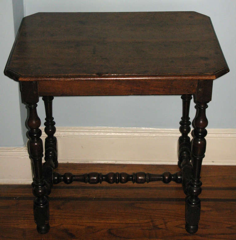 A seventeenth century walnut Louis XIII table with canted corners, molded edge and turned legs and stretchers. 
France, mid-seventeenth century