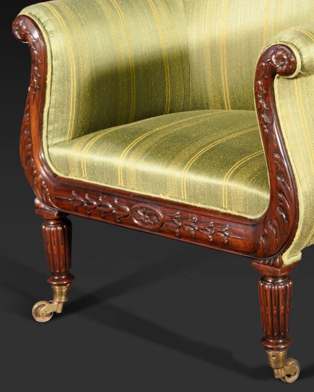 The outscrolled arms and seat rail carved with paterae and husk garlands; raised on tapering reeded legs ending in brass caps and casters.