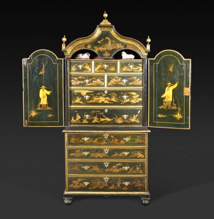 The pagoda-form cornice surmounted by gilt ball-form finials over two arched doors enclosing an arrangement of seven drawers; the lower section fitted with a secretaire drawer opening to pigeonholes and drawers, over three graduated drawers, on bun