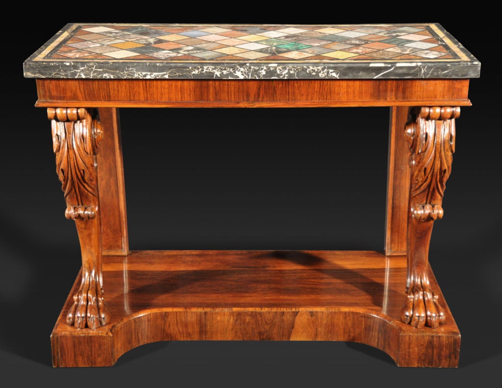 The rectangular black marble bordered top inlaid with assorted stone and marble specimens, over a deep solid frieze; raised on acanthus carved monopodia front supports above a concave-front plinth base.