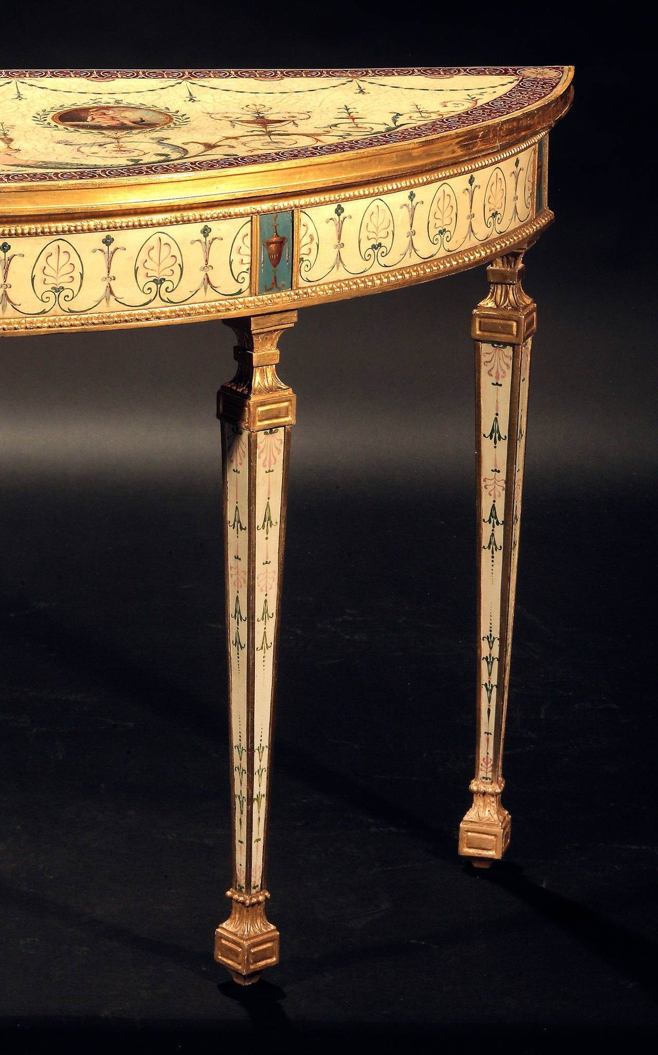 In the manner of Robert Adam, having painted decoration attributed to Pergolesi and Cipriani.
The semi-elliptical top with molded edge, gold and claret colored anthemion border centering medallions most likely painted by Michael Angelo Pergolesi,