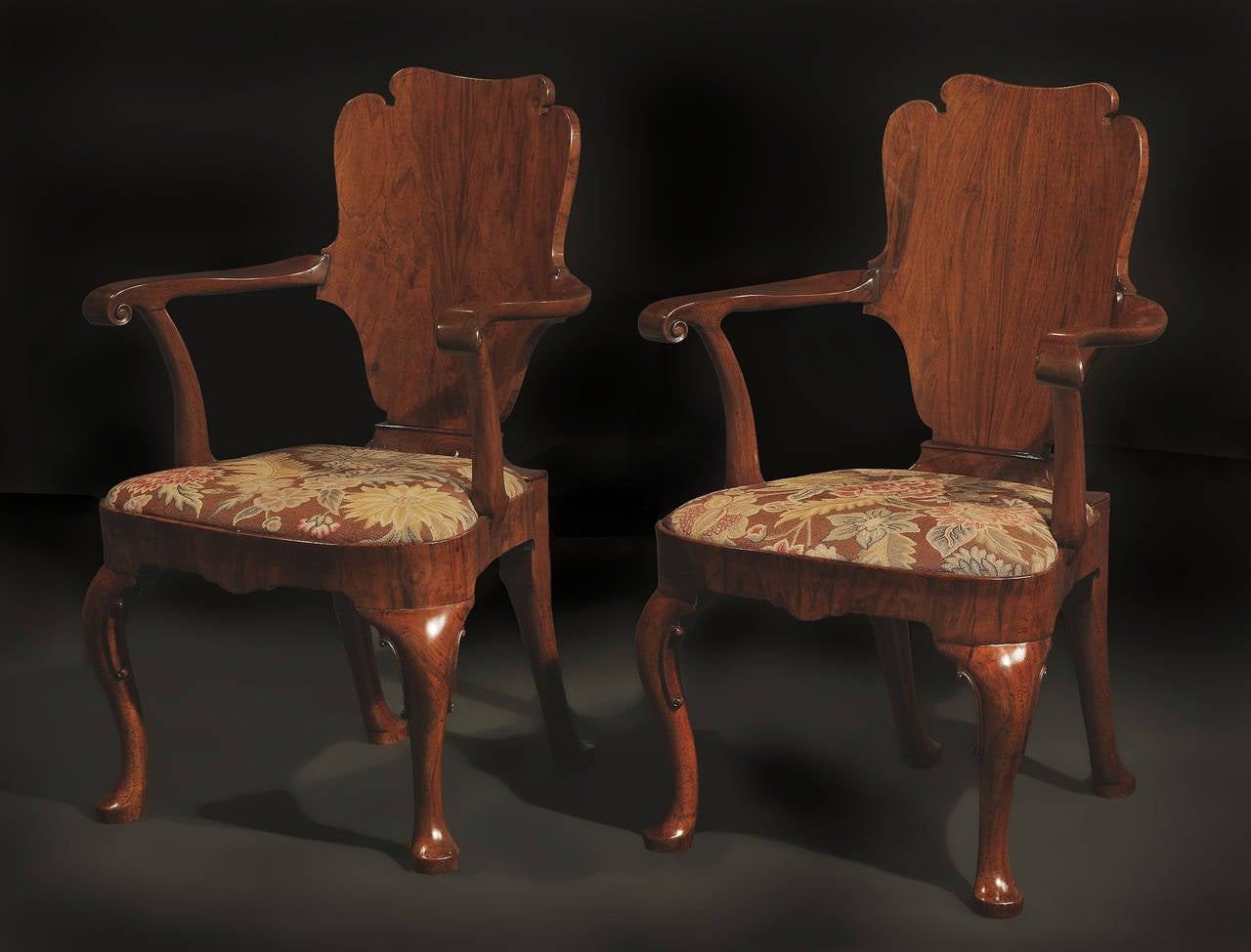 Each with highly figured curved solid back and scroll arms; drop in seat upholstered in floral needlework, on cabriole legs and pad feet. 

Provenance: Percival D Griffiths; Sandridgebury, Hertfordshire.