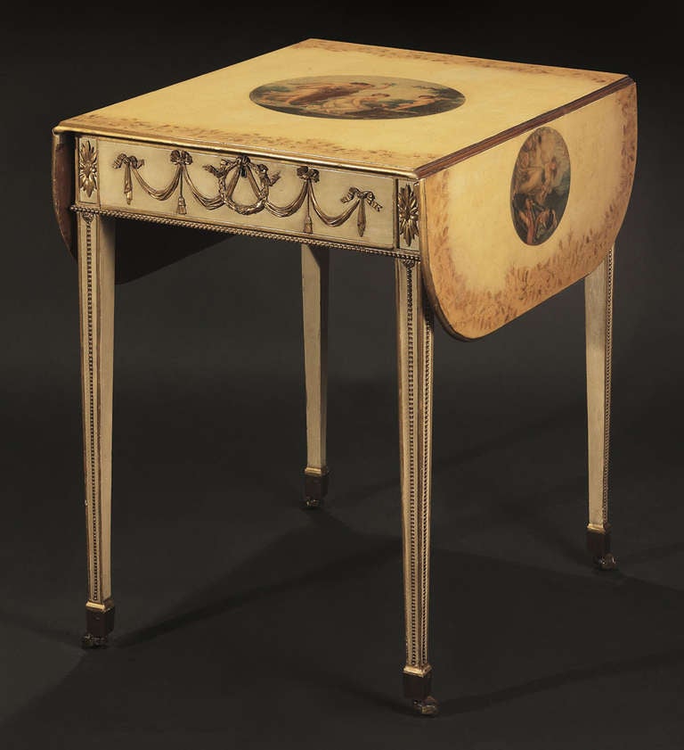 The rectangular top with rounded drop leaves bordered by a broad band of floral and vine-work and decoupaged with engravings after Angelica Kauffmann, over a frieze drawer carved in low relief with ribbon-tied swags; raised on beaded square tapering