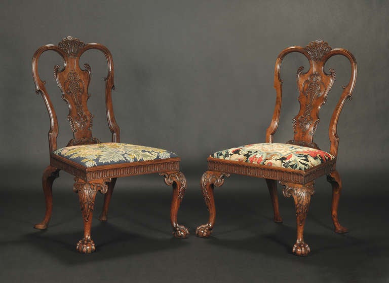 Each with superbly carved shell centring a serpentine crest rail, over a solid back splat with gadrooned scrollwork and diapered panel flanked by conforming stiles; the drop in seats upholstered in two panels of gros point floral needlework, set