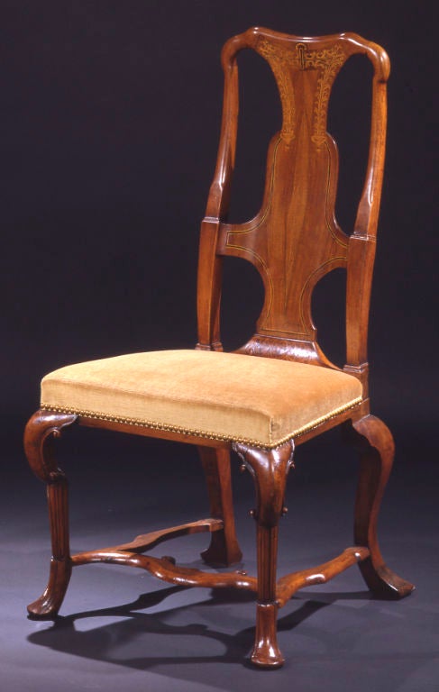 Each with yoked top rail over a shaped backsplat inlaid with foliate sprays and boxwood and ebonised stringing; the over upholstered seat raised on four cabriole legs headed by C-scrolls and joined by an H-form stretcher, terminating in pad feet.