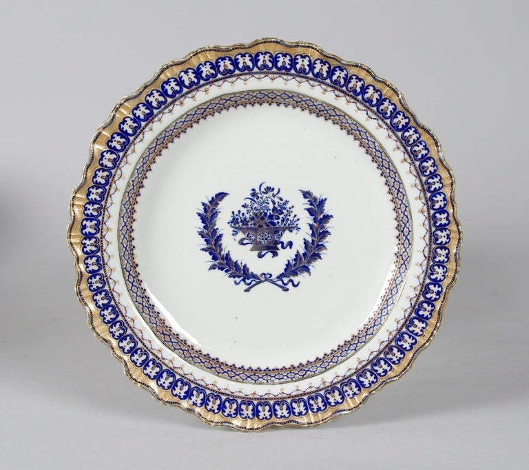 Fine Chinese Export porcelain fruit/dessert service, each piece well painted with a basket of flowers within a wreath tied with a bow; the cavetto and scalloped edge decorated with intricate bands of lambrequins, swags and cartouches; the whole with